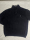 Close-up of vintage Nautica black quarter-zip sweater collar showing grey ribbed lining, size XL tag, silver zipper pull, and embroidered sail chest logo