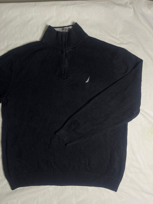 Close-up of vintage Nautica black quarter-zip sweater collar showing grey ribbed lining, size XL tag, silver zipper pull, and embroidered sail chest logo