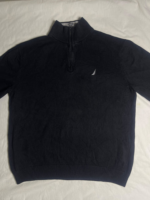 Close-up of vintage Nautica black quarter-zip sweater collar showing grey ribbed lining, size XL tag, silver zipper pull, and embroidered sail chest logo